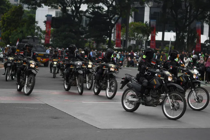 Sejumlah personel Brimob Polda Metro Jaya mengendarai sepeda motor saat mengamankan aksi demosntrasi